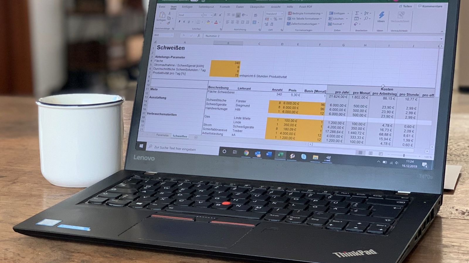 Notebook mit Kaffeetasse: Kalkulation oder Schätzen