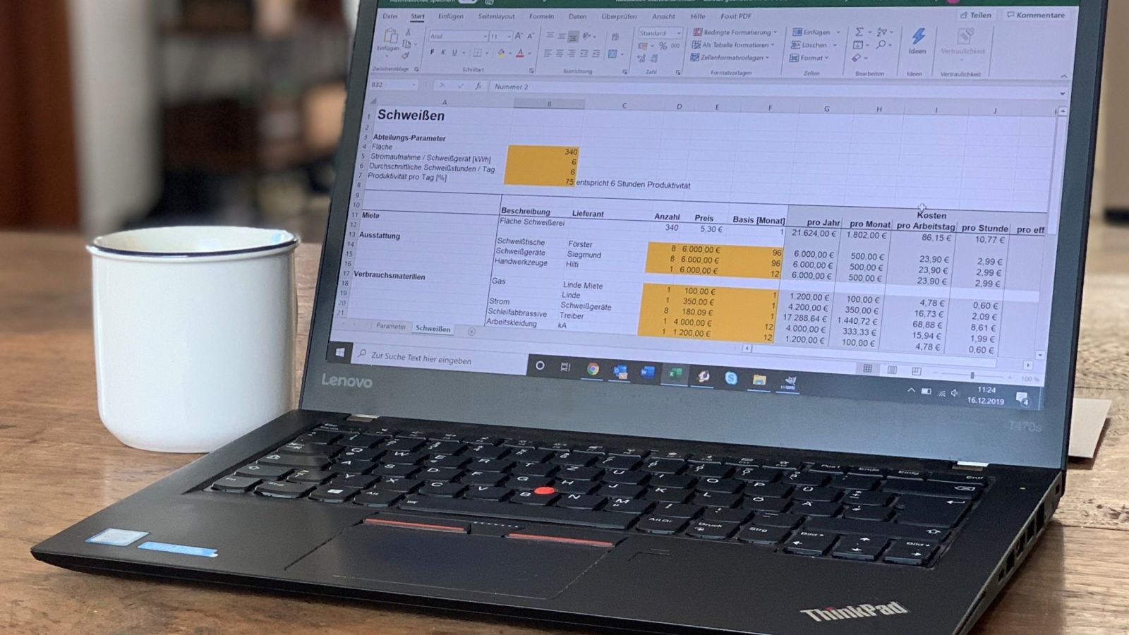 Notebook mit Kaffeetasse: Kalkulation oder Schätzen